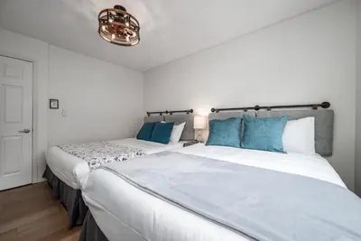 a bedroom with two beds with blue pillows at Luxurious Retreat/Hot Tub/Mountain View/4 Beds in Canmore