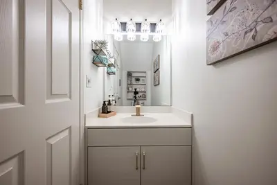 a bathroom with a sink and a mirror at Luxurious Retreat/Hot Tub/Mountain View/4 Beds in Canmore