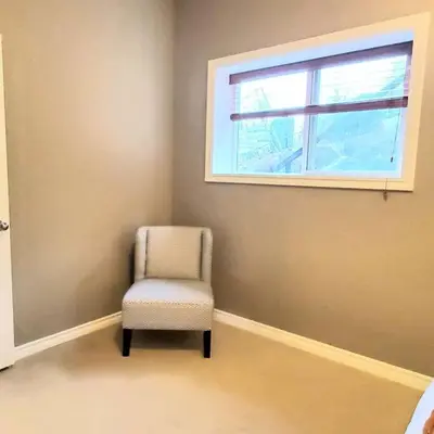 a chair sitting in a room with a window at Spacious 2BR Near HWY 1-Heritage Park - Cultus Lake -Fishing! in Chilliwack