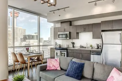 a kitchen and living room with a couch and a table at Luxury 2BR Condo - Downtown City Views in Calgary