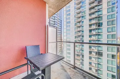 a bench on a balcony with a building at Luxury 2BR Condo - Downtown City Views in Calgary