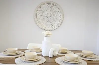 a dining room table with white dishes and a mirror at BoHo Retreat with King Beds, Golf, Disney+, Near WEM in Edmonton