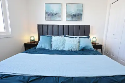 a bedroom with a blue bed with blue pillows at BoHo Retreat with King Beds, Golf, Disney+, Near WEM in Edmonton