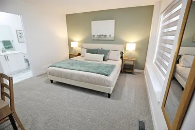 a bedroom with a bed and a mirror at BoHo Retreat with King Beds, Golf, Disney+, Near WEM in Edmonton