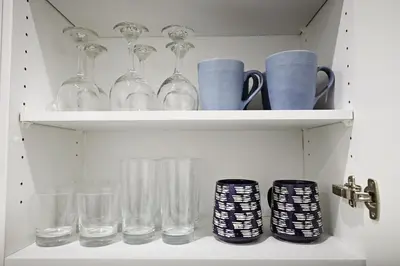 a shelf with glasses and cups on it at Stylish Retreat with King Bed, Long Stays, WEM, Disney+ in Edmonton