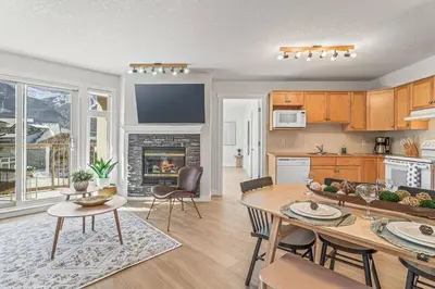 a kitchen and a living room with a table and chairs at W411 NEW- TOP of the World Canmore MTN Retreat in Canmore