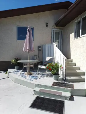 a patio with an umbrella and a table and chairs at Cozy Red Deer Suite for 3 in Red Deer
