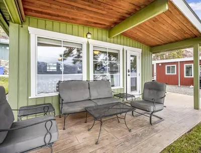 a screened in porch with chairs and a table at Secluded Cabin On The Lake #7 in West Kelowna