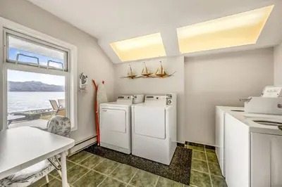 a kitchen with a washer and dryer and a table at Secluded Cabin On The Lake #7 in West Kelowna