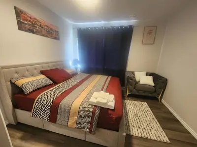 a bedroom with a bed and a chair at Cozy one bedroom in Airdrie in Airdrie