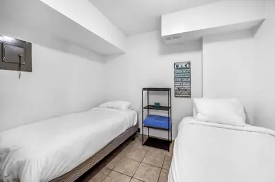 two beds in a room with white walls at The Lakeside Condo #202 in West Kelowna