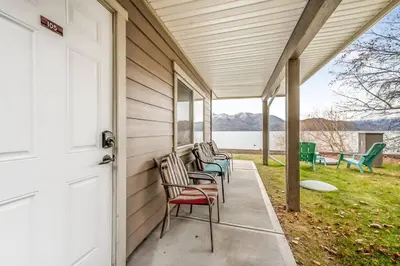 a porch with chairs on the side of a house at The Lakeside Cabin with wide outside space #105 in West Kelowna