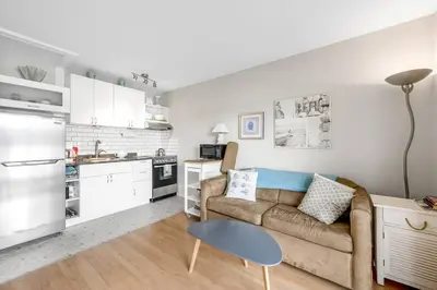 a living room with a couch and a kitchen at The Lakeside Cabin with wide outside space #105 in West Kelowna