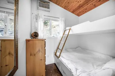 a small bedroom with a bed and a mirror at Beautiful Cabin Right next to Lake Okanagan #5 in West Kelowna