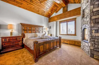a bedroom with a bed and a stone wall at Inuksuk Lodge - 4800 sq ft of Big White Excellence! in Big White