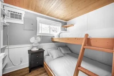 a small bedroom with two bunk beds and a window at Lakeside Serenity Retreat #10 in West Kelowna