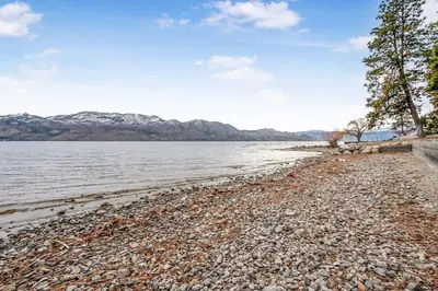 a rocky beach next to a body of water at Lakeside Serenity Retreat #10 in West Kelowna