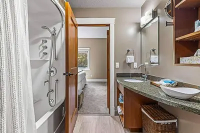 a bathroom with two sinks and a shower at Gorgeous Mountain Condo - Hot Tub & Pool managed by Little Sister Getaways in Canmore