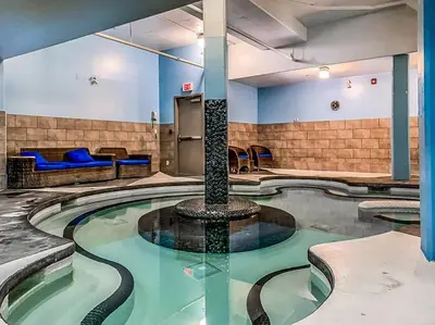 a swimming pool with a fountain in a room at Gorgeous Mountain Condo - Hot Tub & Pool managed by Little Sister Getaways in Canmore
