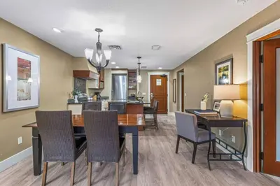 a dining room and kitchen with a table and chairs at Gorgeous Mountain Condo - Hot Tub & Pool managed by Little Sister Getaways in Canmore