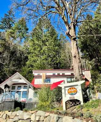 a house with a sign in front of it at Sungate on Salt Spring - Luxurious Suite with Cedar Hot Tub & View in Salt Spring Island