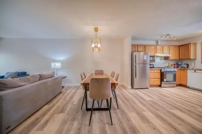 a kitchen and living room with a table and a couch at Bow Valley Chalets-Entire 2 King Bedrooms townhouse in Canmore