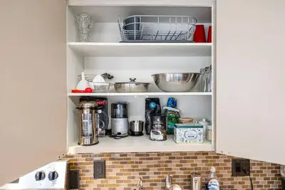 a kitchen cabinet filled with lots of kitchen items at YEG Chic Luxury Accommodation in Edmonton