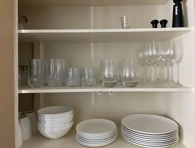 a shelf filled with glasses and plates and bowls at YEG Chic Luxury Accommodation in Edmonton