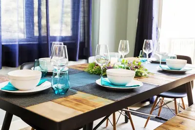 a wooden table with bowls and wine glasses on it at Modern Home - King Bed - Garage - Long Stays in Edmonton