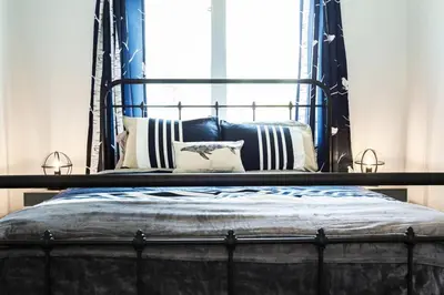 a bed with a blue frame and pillows on it at Modern Home - King Bed - Garage - Long Stays in Edmonton