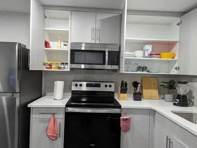 a kitchen with a black stove and a microwave at The Fruitful Vineyard- A Beautiful 2 Bed Suite in Calgary