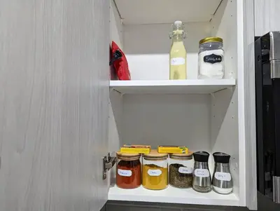 a cupboard filled with jars of food and drinks at The Fruitful Vineyard- A Beautiful 2 Bed Suite in Calgary