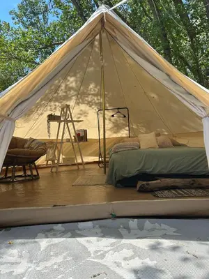 a tent with a bed and a chair on a deck at #Y2 Sage & Wildflower Yurt in Drumheller