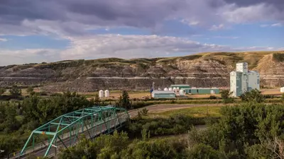 a bridge over a road with a mountain in the background at #Y7 Whole New World Yurt in Drumheller