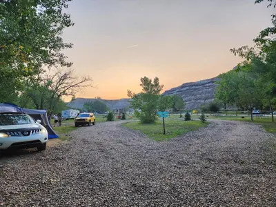 a gravel road with cars parked on the side at #Y7 Whole New World Yurt in Drumheller