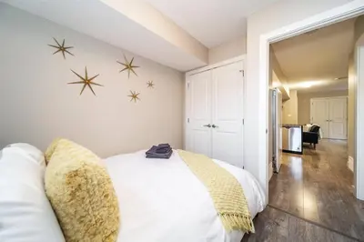 a bedroom with a white bed with snow stars on the wall at Bright Modern Suite - Netflix - WiFi - Long Stays in Edmonton