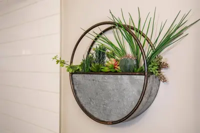 a metal planter hanging on a wall with plants at Bright Modern Suite - Netflix - WiFi - Long Stays in Edmonton