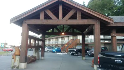 a large wooden pavilion with cars parked in a parking lot at Big Rock Motel in Campbell River