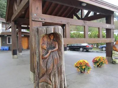 a wooden statue of a woman hugging a baby at Big Rock Motel in Campbell River