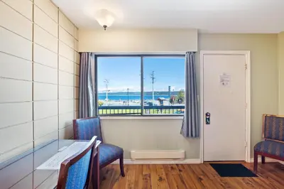 a room with a table and chairs and a window at Big Rock Motel in Campbell River