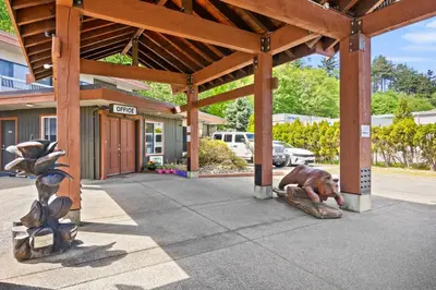 a dog laying on a log in front of a building at Big Rock Motel in Campbell River