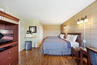 a hotel room with a bed and a flat screen tv at Big Rock Motel in Campbell River