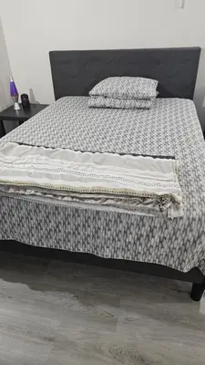 a bed with a blanket and pillows on it at Bright and Cozy Room with Free Parking in Edmonton