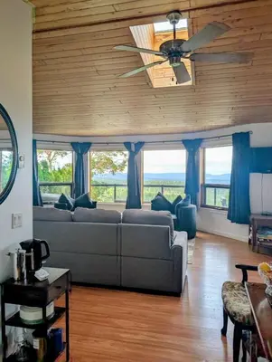 a living room with a couch and a ceiling fan at Armand Heights in Ganges
