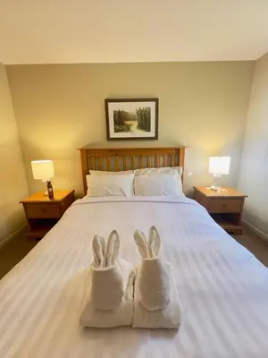 two towels with bunny feet sitting on a bed at Timberline Condos - Aspen Building in Fernie