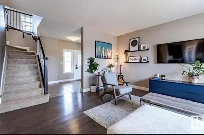 a living room with a staircase and a tv at Best home with lake view in Edmonton