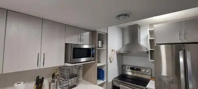 a kitchen with white cabinets and a stainless steel refrigerator at Cozy 2-Bedroom Basement Guest Suite with Private Entrance and Proximity to the Airport in Edmonton