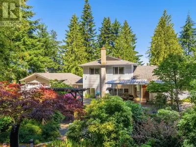 a white house with trees and bushes at Beautiful home with one acre land for leisure time in Vancouver Island in Nanaimo