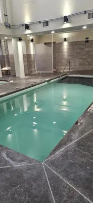 a swimming pool with green water in a building at Gracie's Place Business license 11787 in Canmore