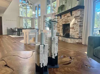 a living room with a stone fireplace and a table at Verde Vista - Steam Shower - Theatre - Ping-Pong in Fairmont Hot Springs